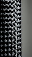 Close-up macro shot of black carbon fiber weave pattern showing detailed textile structure and industrial material texture for automotive and aerospace applications.