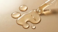 Dropper dispensing golden serum or oil onto puzzle piece shape with liquid droplets on beige background, suitable for skincare, wellness, and cosmetic product marketing.