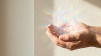 Hands holding glowing spiral light energy orb against neutral background, representing innovation, power, technology, and spiritual growth for design projects.