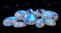Collection of luminous opal gemstones with rainbow fire displaying blue, pink and green flashes on dark background for jewelry design and luxury concepts.