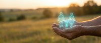 Young adult male hand holding glowing holographic family figures against rural sunset landscape, representing digital connection, virtual relationships, and technology-based communication for web and app design.