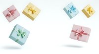 Colorful gift boxes with ribbons floating on white background, isolated presents in pink, gold, and blue tones for holiday, birthday, and celebration design projects.