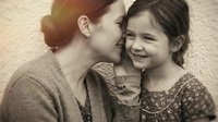 Loving mother and young daughter sharing tender moment together, warm sepia toned portrait capturing family bond and maternal affection in intimate setting.