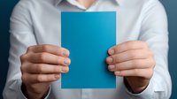 Hands holding blank blue paper card against white shirt background, mockup for business presentation or announcement. Clean minimalist design layout.