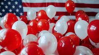 Red and white balloons against American flag background, creating patriotic atmosphere for Independence Day, political events, or national celebrations.
