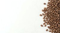 Roasted coffee beans scattered on white background, isolated for beverage packaging, cafe design, and culinary content.