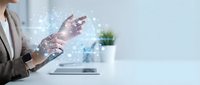 Businesswoman using laptop with digital holographic interface and data visualization, representing technology, innovation, and modern business solutions.
