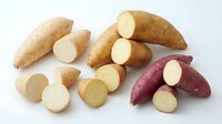 Fresh sweet potatoes and yams with sliced pieces showing creamy flesh, perfect for healthy cooking and nutrition concepts on white background.