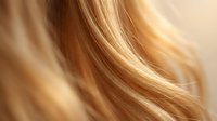 Flowing blonde hair strands with golden highlights creating smooth waves and natural texture for beauty and haircare concepts.