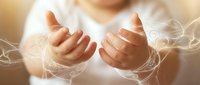 Open hands with glowing energy lines and light effects suggesting healing, spirituality, or magical power in warm golden atmosphere.