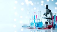 Laboratory equipment with microscope and colorful chemical solutions in glassware on bright background for scientific research and education.