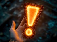 Glowing orange exclamation mark floating above open palm against dark background, magical light particles create warning symbol effect for attention concepts.