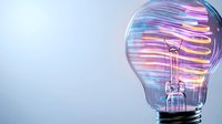 Glowing light bulb with colorful neon spiral trails inside on blue background, representing innovation, creativity and bright ideas in technology.