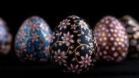 Decorative Easter eggs with delicate pink floral pattern on dark background, traditional painted ornaments and golden swirls on black surface, holiday celebration.