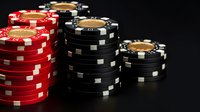 Stacks of red and black casino poker chips on dark background with dramatic lighting, showing gambling and gaming concept for casino entertainment.
