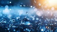 Water drop splash creating bubble shape on wet surface with bokeh light effect and sun flare in blue tones, macro photography for fresh nature concept.