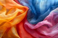 Colorful textile fabric with orange, blue, and pink crinkled textures creating soft waves and folds, suitable for fashion design backgrounds.