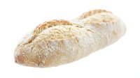 Fresh baked artisan bread loaf with golden crust and flour dusting isolated on white background for bakery and food design projects.