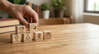 Hand placing wooden cube with customer service icons on desk representing business support and quality management concepts for corporate training.
