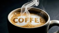 Steaming hot coffee in a dark ceramic mug with foam spelling COFFEE, rising steam on dark background, cozy cafe atmosphere.
