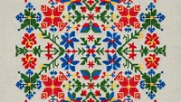 Traditional folk embroidery cross stitch pattern with colorful floral motifs on beige fabric background. Ethnic needlework design for textile crafts and decoration.