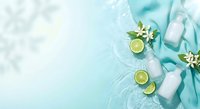 Natural skincare cosmetic bottles with lime slices and jasmine flowers on turquoise water background for spa beauty treatment and organic wellness products.