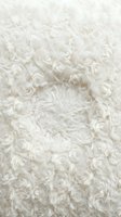 Cream-colored rosette fabric with dimensional floral texture, ideal for wedding backdrops, event decor, and upholstery design projects.