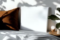 Minimalist bedroom interior with white canvas mockup on bed, brown velvet pillow, small lamp and plant shadow play on wall creating cozy atmosphere.
