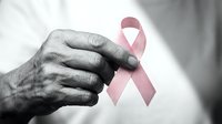 Elderly hands gently holding pink awareness ribbon symbolizing breast cancer support, hope and solidarity in healthcare advocacy campaign.