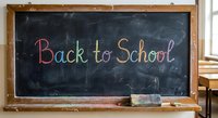 Colorful chalk text Back to School written on black chalkboard in wooden frame classroom setting for education and learning concepts.
