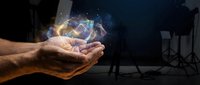 Close-up of male hands holding glowing digital hologram with interconnected network nodes and light particles against dark studio background for technology concepts.