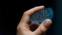 Hand holding glowing digital cloud shape made of binary code numbers, representing cloud computing and data storage technology on dark background.