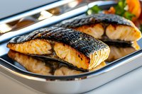 Grilled salmon fillets with crispy skin served on metal tray, close up view of cooked fish steaks with golden crust and juicy flesh, restaurant food.