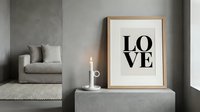 Minimalist Scandinavian living room with framed LOVE typography print, candle, and neutral gray tones for modern home decor inspiration.