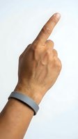 Male hand with medium skin tone wearing gray wristband, pointing upward with index finger against white background. Suitable for gestures, direction, attention, and communication concepts.