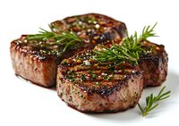 Grilled beef tenderloin steaks seasoned with fresh rosemary sprigs, black pepper, and coarse salt on white background, juicy meat with char grill marks.
