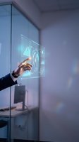 Businessman in dark suit touching holographic display with glowing data analytics charts and graphs for technology, finance, and business intelligence applications.