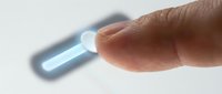 Male finger touching glowing blue digital interface button on white surface for modern technology and user interaction concepts.