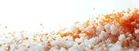 Gourmet sea salt crystals with vibrant orange and red spices scattered on white surface, creating a colorful seasoning blend for culinary use.