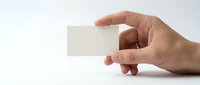 Hand holding blank white business card mockup on clean background for branding and corporate identity design projects.