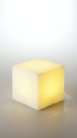 Glowing cube lamp with warm yellow light emission on neutral surface, modern minimalist design for interior decoration and ambient lighting solutions.