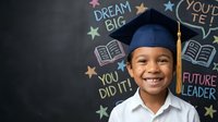 Young African American boy wearing graduation cap smiling against chalkboard with motivational messages. Educational achievement and success concept.