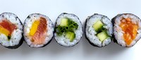 Fresh sushi rolls with salmon, tuna, cucumber and rice wrapped in nori seaweed arranged in line on white background, traditional Japanese cuisine.