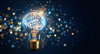 Glowing light bulb with brain inside surrounded by sparkling particles and bokeh lights on dark blue background representing innovation and creative thinking.