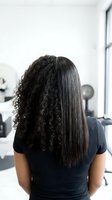 Hair straightening before and after transformation showing curly and straight textures on mixed race woman in modern salon setting for beauty treatments.