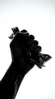 Clenched fist holding crumpled currency notes against white background, symbolizing financial struggle, economic hardship, and money problems in black and white.