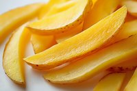 Fresh juicy mango slices arranged in rows showing bright yellow flesh and natural texture, macro food photography for healthy eating and tropical fruit concept.