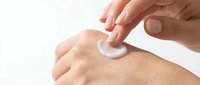 Person applying moisturizing cream or lotion to arm skin for hydration, skincare routine, dermatology treatment, and cosmetic beauty product use.