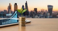Green plant growing from golden coins with upward arrow graph on wooden desk against blurred city skyline at sunset representing financial growth and investment success.