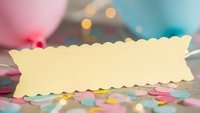 Blank scalloped paper banner with colorful confetti and bokeh lights for party invitations, crafting projects and celebration designs.